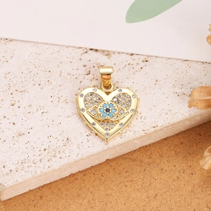Detail view of heart-shaped gold-plated evil eye pendant with embedded zircons on stone