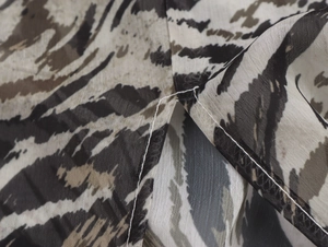Detailed macro view of sheer chiffon fabric with sexy tiger stripe pattern and hem stitching