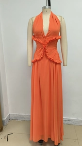 Dettaglio dell'abito lungo in chiffon arancione con scollo a V, balze e tessuto a pieghe