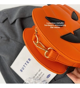 Close-up of golden hardware and orange Saffiano texture on pumpkin crossbody bag