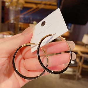 Detail of S925 silver post hoop earrings with black enamel and gold plating finish