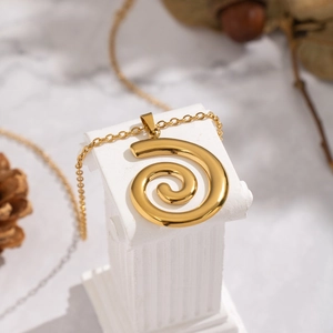 Élégant collier spirale en acier inoxydable plaqué or 18 carats sur fond de marbre