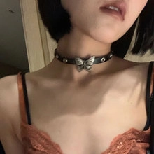 Detail of a black leather choker featuring a silver butterfly pendant worn on neck