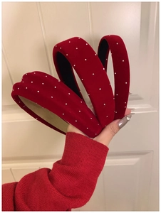 Close-up of three red velvet headbands with silver rhinestones and various widths