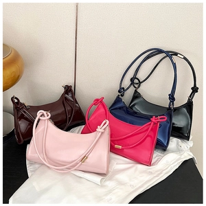 Detail of minimalist patent leather baguette bags with knotted shoulder straps in four colors