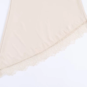 Gros plan détaillé sur l'ourlet en dentelle de cils abricot de la robe en satin