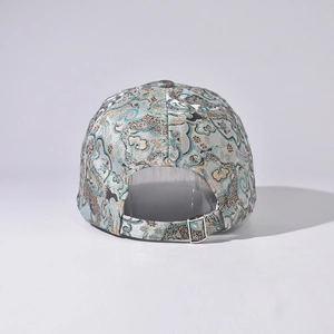 Detail of blue brocade baseball cap featuring silver metal buckle and dragon pattern