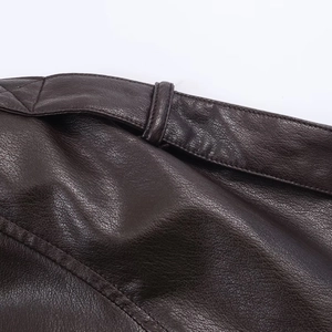 Detailed macro view of dark brown faux leather texture and stitching on jacket waist