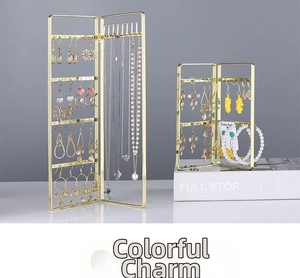 Detail of gold folding metal jewelry stand with earring holes and necklace hooks