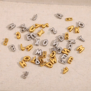 Vue détaillée de pendentifs alphabet en or 18 carats et argent pour bijoux artisanaux