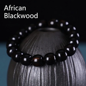 Gros plan macro de perles en bois noir africain poli sur un support en céramique
