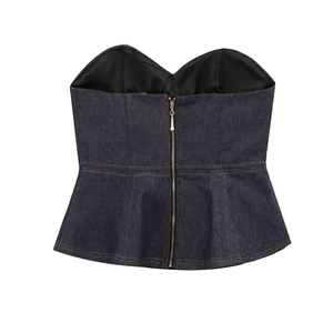 Macro detail of dark blue denim bustier top featuring a back central metal zipper closure