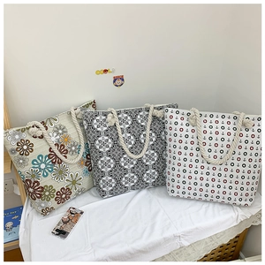 Close-up of printed canvas tote bags with vintage floral patterns and hemp rope handles