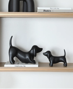 Minimalist matte black ceramic dachshund figurines set on a modern wooden shelf decor