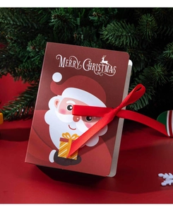 Close-up of magic book style Christmas candy box with red ribbon and Santa illustration
