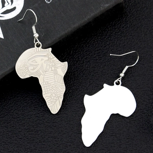 Vue macro de boucles d'oreilles carte Afrique argentées avec gravure de l'Oeil d'Horus