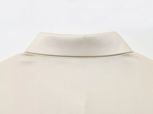 Gros plan détaillé de l'encolure dos de cette chemise en satin de soie crème aux coutures