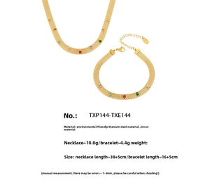 Détail d'un ensemble de bijoux en acier titane avec zircons colorés et chaîne maille