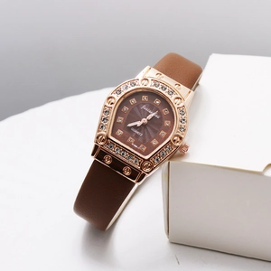 Detail of rose gold horseshoe quartz watch with crystal bezel and brown leather strap