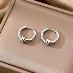 Silver stainless steel hoop earrings with sphere charm shown in a textured jewelry box