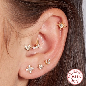 925 sterling silver ear piercing set featuring star, opal hoop, and floral studs on model