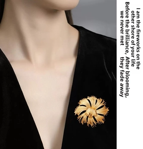 Detail of gold floral brooch with brushed metal texture on a black velvet suit