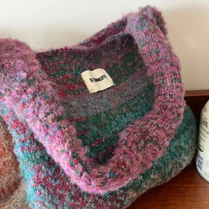 Close-up of internal brand label on chunky gradient knit tote bag with plush texture