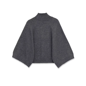 Detailed close-up of a dark grey knit poncho sweater with ribbed high collar and hem