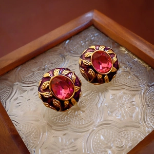 Close-up of vintage oval earrings with gold leaves, purple enamel and pink crystal