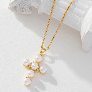 Detail of elegant gold cross pendant necklace with white pearls and small diamonds