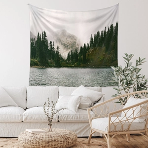 Detailed view of nature landscape tapestry hanging over a white sofa in a modern room