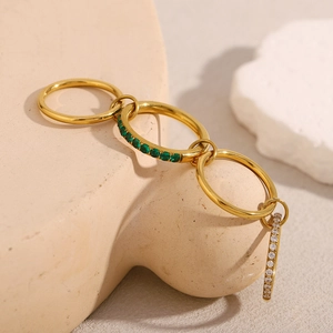Macro view of gold-plated stacked rings with green and white zircons on stone decor