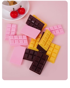 Detailed view of realistic PVC chocolate charms in pink and brown on a dessert setting
