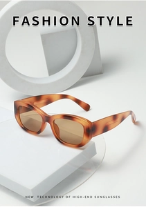 Detail view of tortoiseshell square sunglasses with textured wide temples and tinted lenses