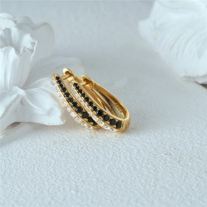 Detail of gold huggie earrings with double row black and clear crystal inlays