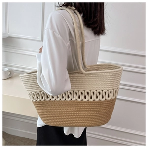 Detail view of large straw tote bag featuring khaki and beige woven cotton rope texture