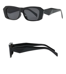 Detail view of black rectangular sunglasses with geometric cut wide temples and dark lenses