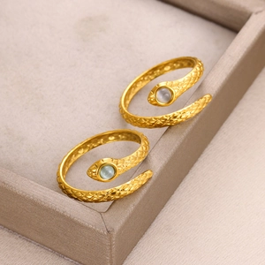 Detailed view of two gold-plated snake rings featuring sparkling cat's eye stone eyes