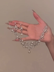Detailed close-up of floral jewelry set with sparkling rhinestones and elegant pearls