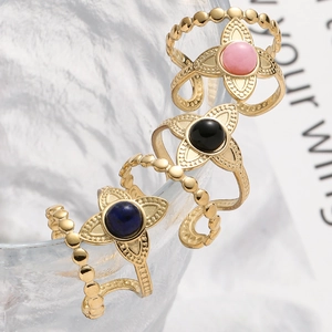 Detailed macro view of vintage gold flower rings with colorful stones on glass rim