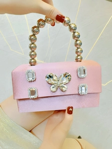 Detailed shot of pink satin evening clutch with crystal butterfly and silver bead handle