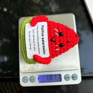 Detailed view of handmade crochet watermelon doll with positive card weighing 18.1 grams