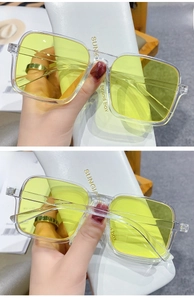 Detail view of square transparent frames with yellow lenses and metallic temple accents