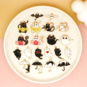 Detail of Halloween cat enamel charms with bat wings and pumpkin candy on ceramic tray