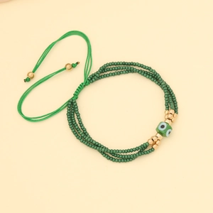 Detail of beaded evil eye bracelet with green layers and adjustable woven drawstring cord