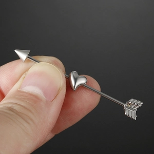 Polished stainless steel industrial barbell featuring a silver heart and arrow design