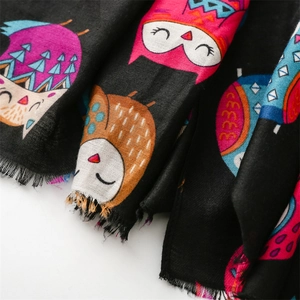 Close-up of linen-feel scarf showing colorful owl patterns and raw edge texture