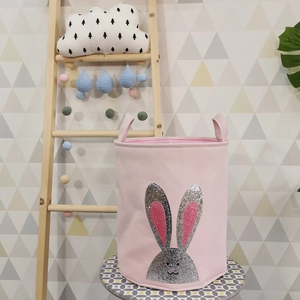 Detail of pink fabric toy storage bin featuring a shimmering sequin bunny design