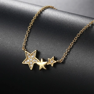 Close-up of gold star pendant necklace with cubic zirconia pavé and polished stars