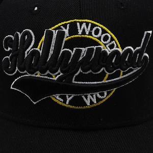 Macro detail of 3D Hollywood embroidery on high-quality black twill baseball cap fabric